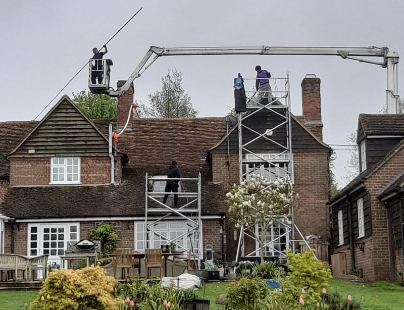The Moss Cleaners using cherry picker and scaffolding to clean roof safely and professionally in Billingshurst, West Sussex